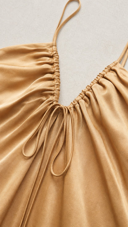 Close-up detail of front ruching and drawstring on champagne dress