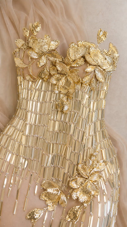 Detailed close-up of metallic gold 3D floral appliques and vertical beadwork on bodice