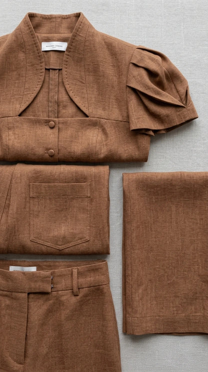 Flat lay detail showing texture, buttons, and collar of brown two-piece set