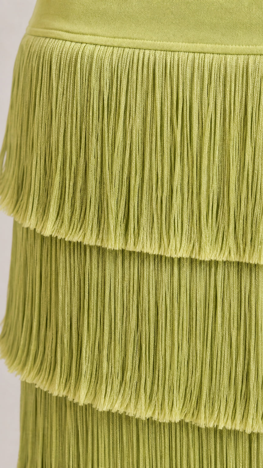 Close-up detail of textured green tiered fringe trim