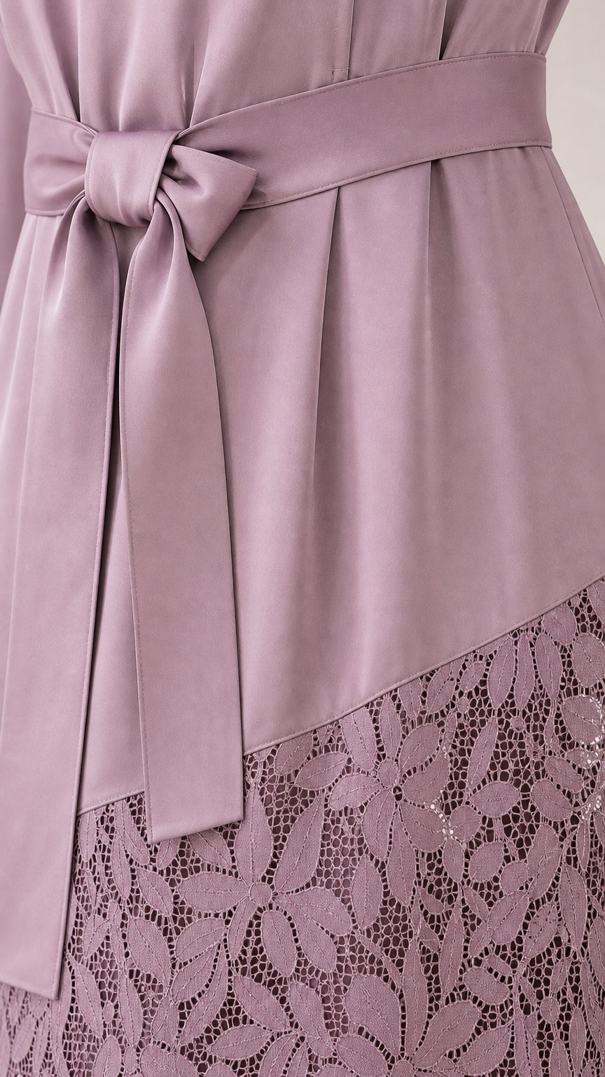 Close-up of waist tie and lace hem detail on mauve dress