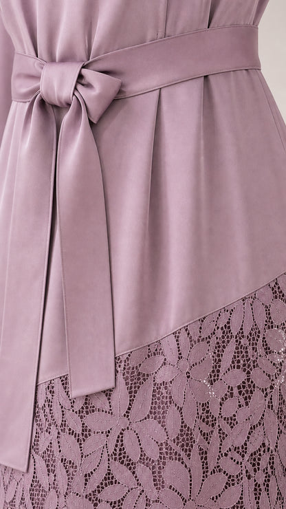 Close-up of waist tie and lace hem detail on mauve dress