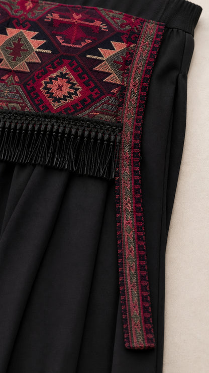Close-up detail of geometric woven pattern with fringe trim and black fabric
