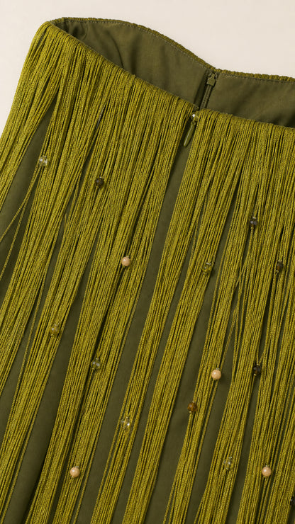Close-up detail of beaded fringe texture and concealed zip on olive green dress