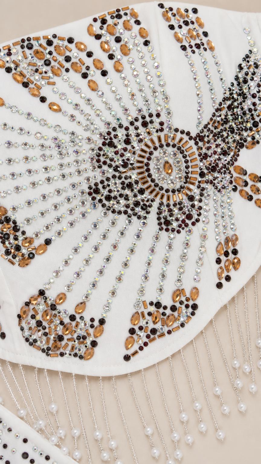 Close-up detail of intricate starburst crystal and beadwork with hanging fringe