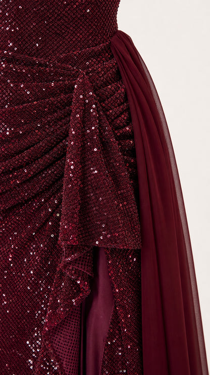 Close-up detail of burgundy sequin fabric and ruched side drape