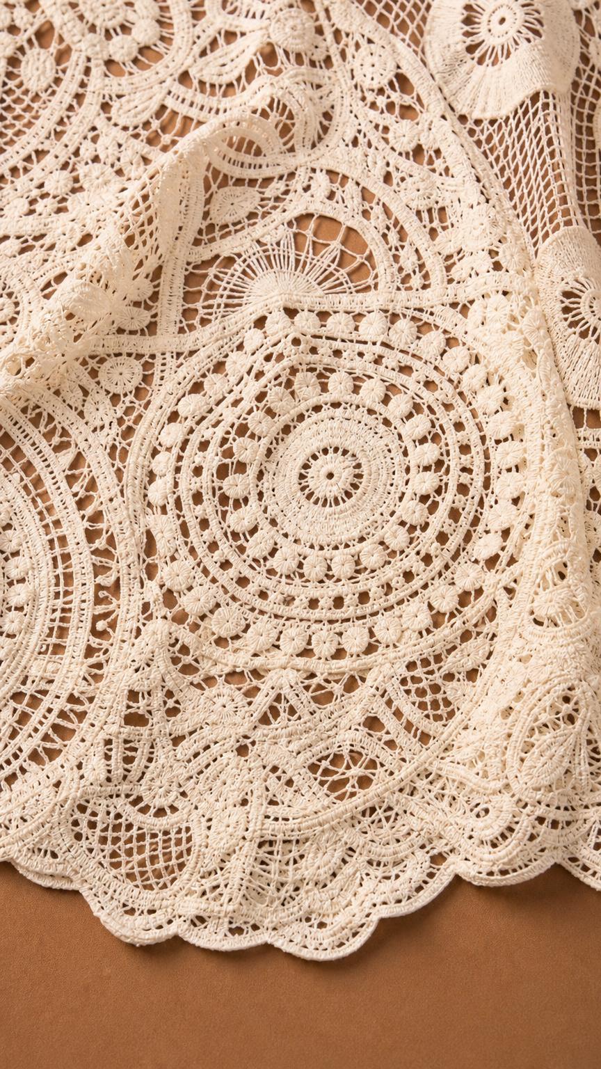 Close-up detail of crochet-style lace pattern and scalloped hem