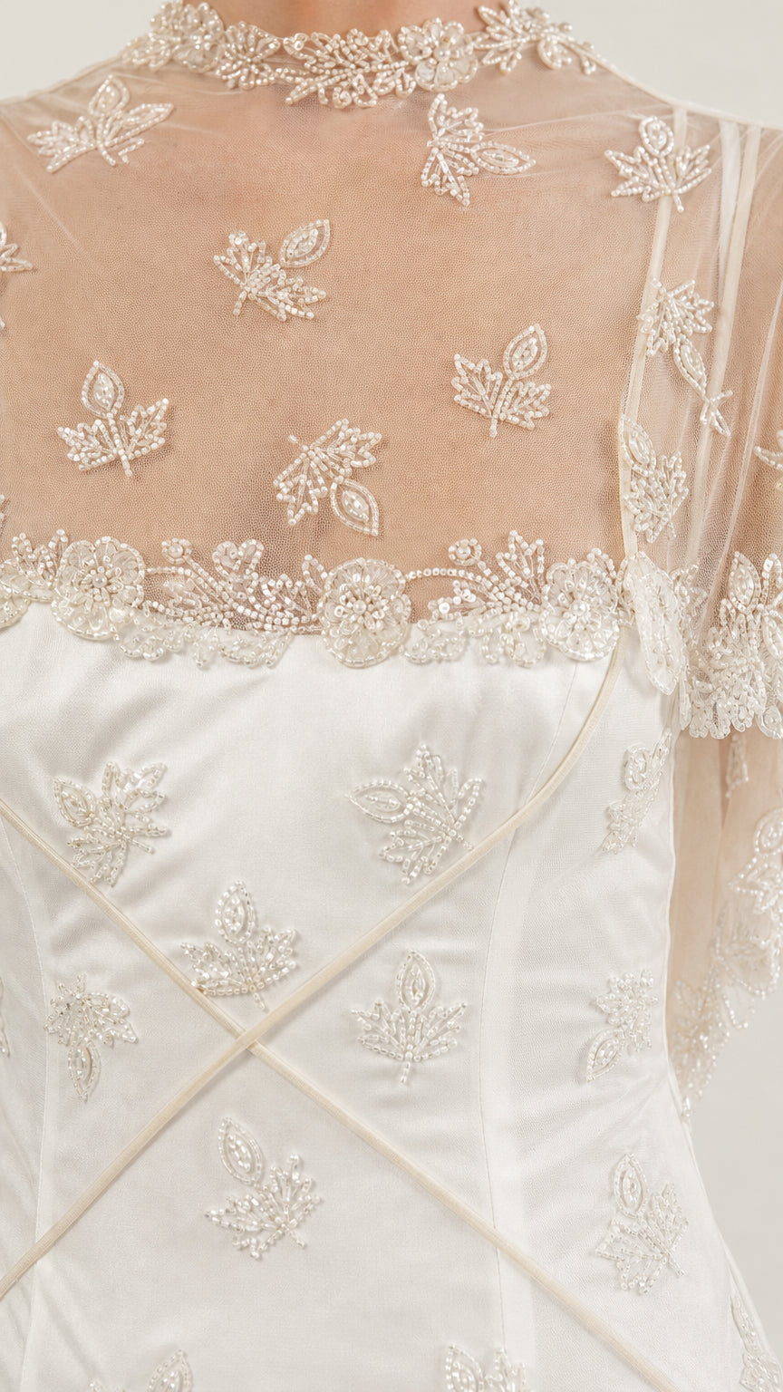 Close-up detail of beaded leaf embroidery and high illusion neckline