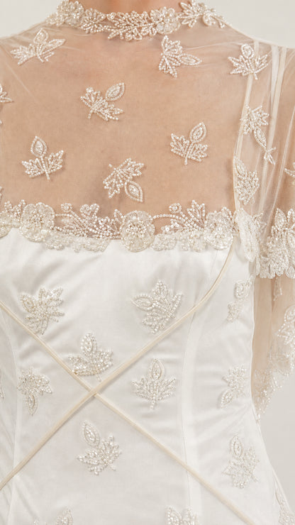 Close-up detail of beaded leaf embroidery and high illusion neckline