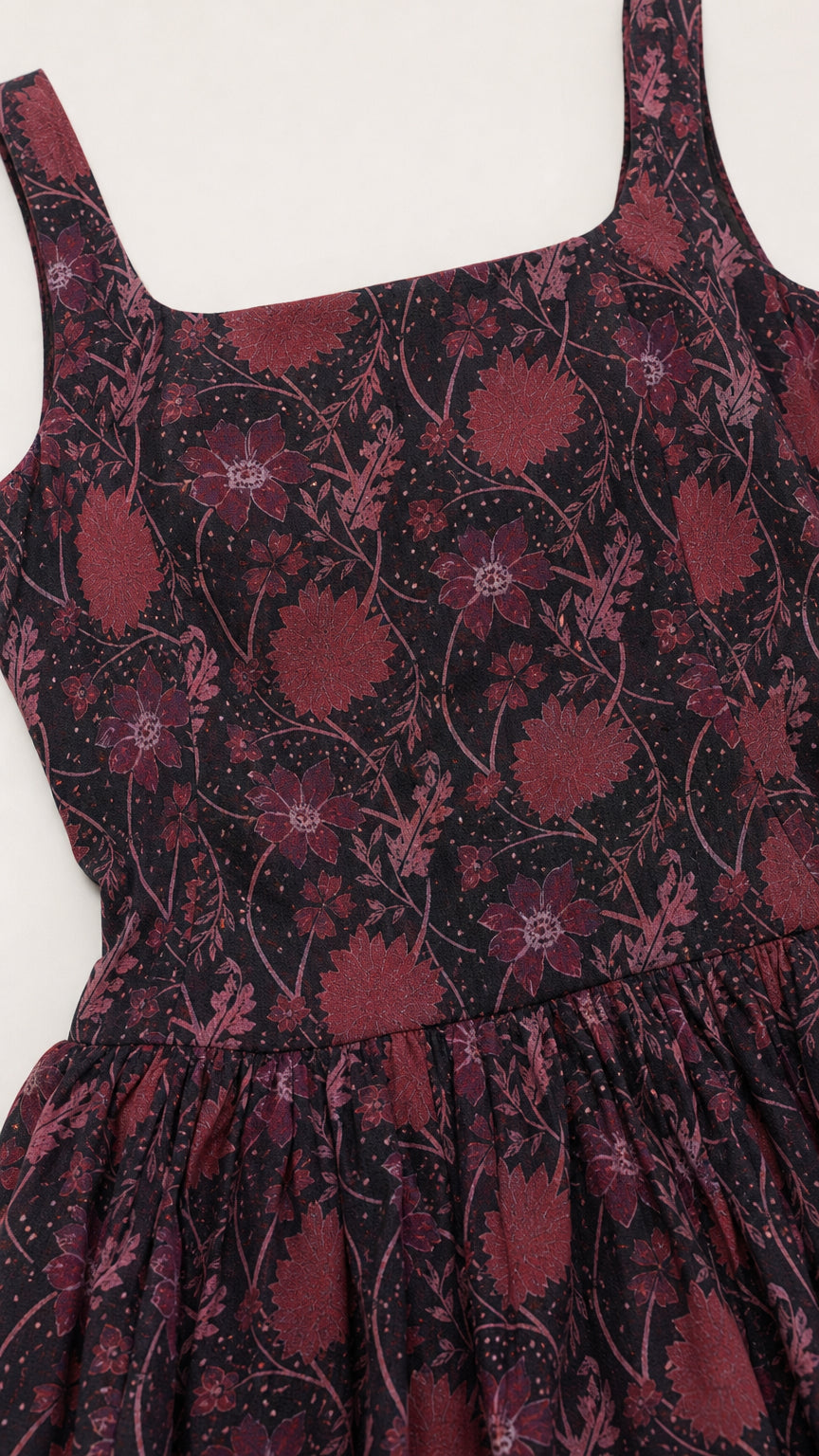 Close-up detail of plum floral fabric texture and square neckline