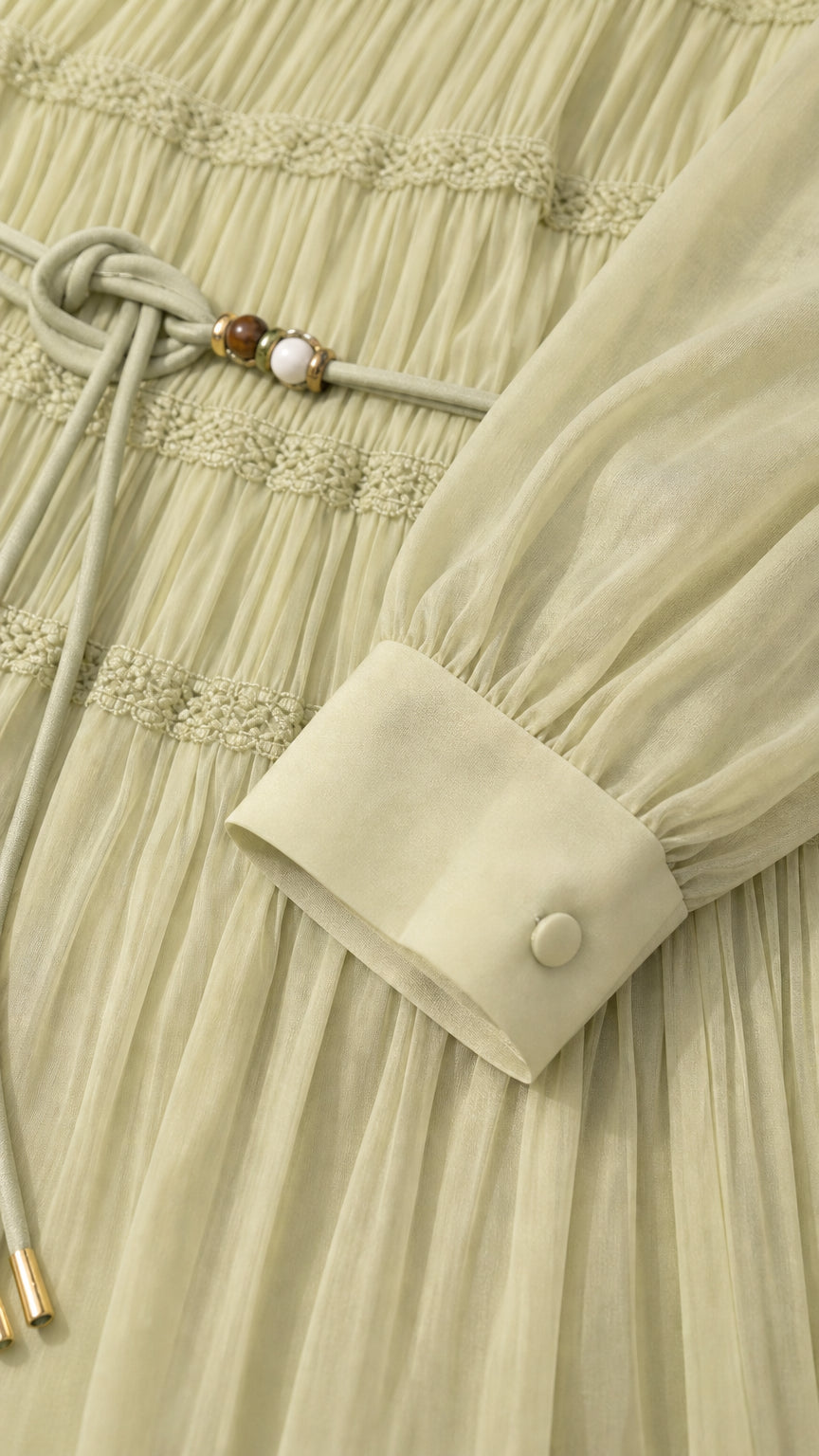 Close-up detail of bodice pintucks, sleeve cuff, and beaded waist belt