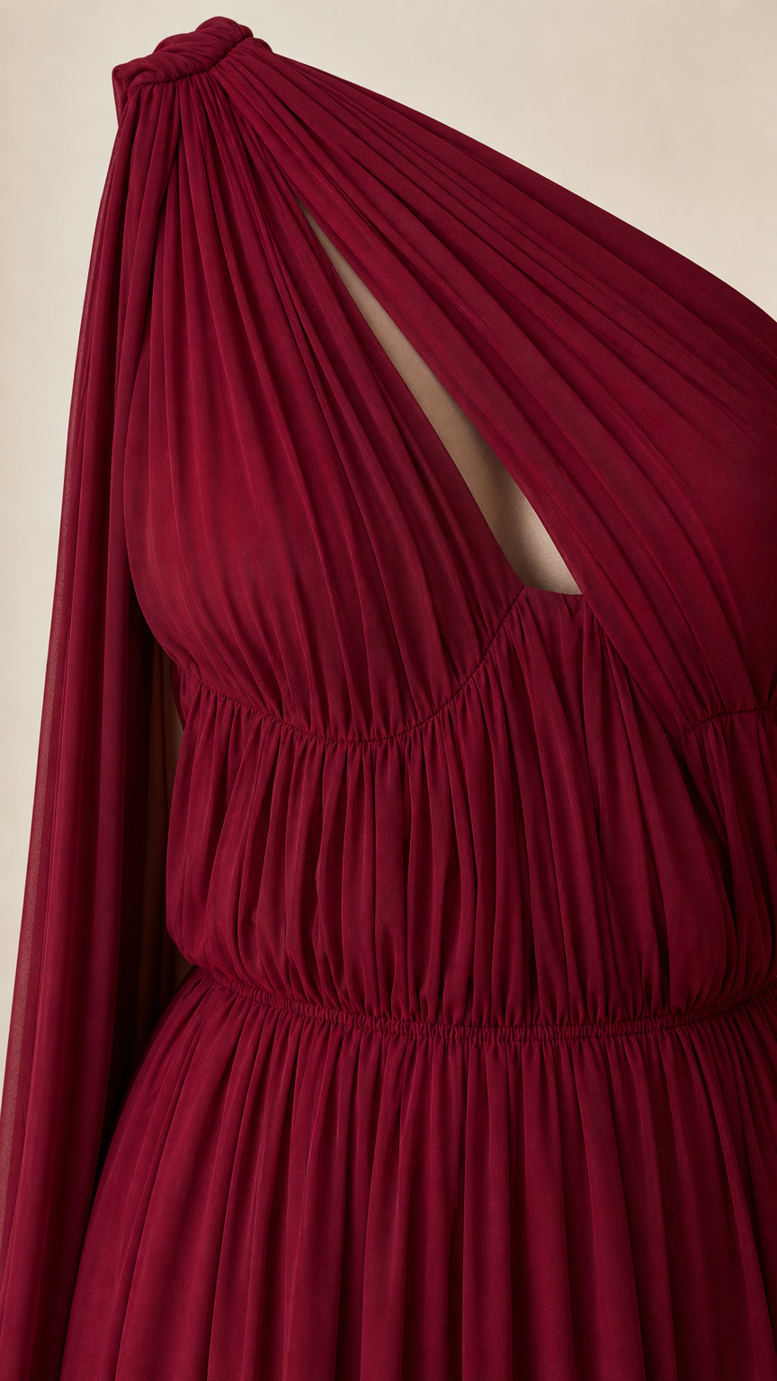 Close-up of bodice, ruching, and cutout detail on burgundy dress