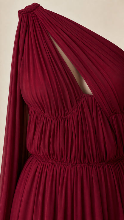 Close-up of bodice, ruching, and cutout detail on burgundy dress