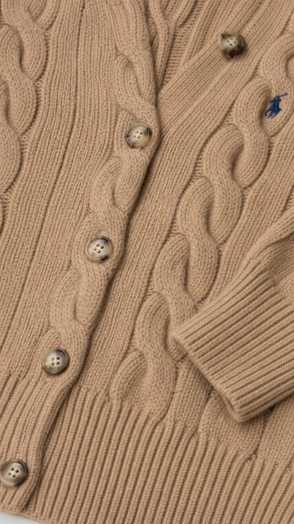 Detailed close-up of textured cable-knit pattern and button closure on camel cardigan