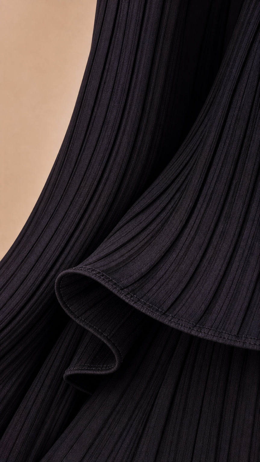 Close-up detail of black vertical ribbed knit fabric and hem