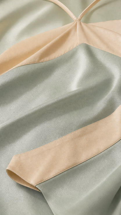 Close-up detail of smooth sage and cream satin fabric and stitching