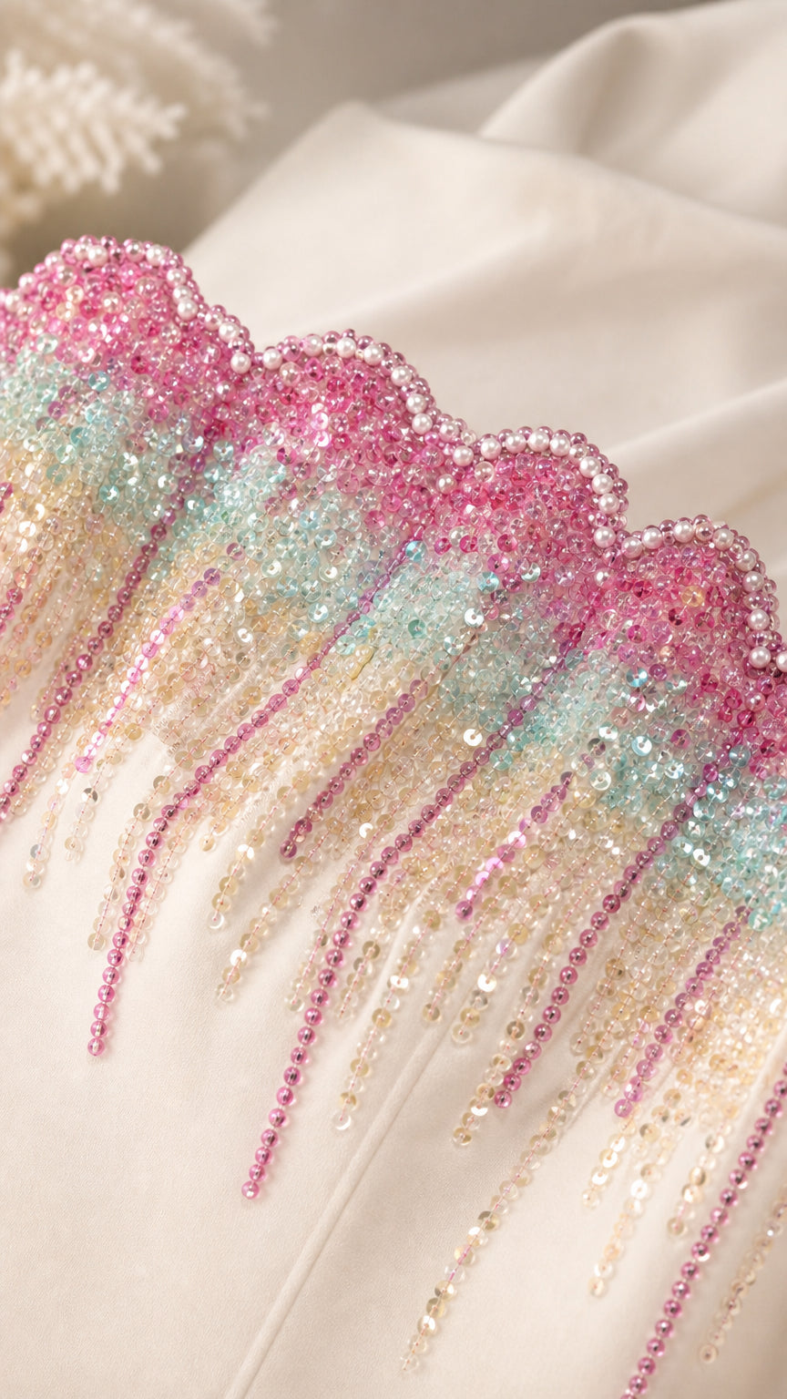 Close-up of pastel multicolor sequined and beaded drop trim along dress neckline