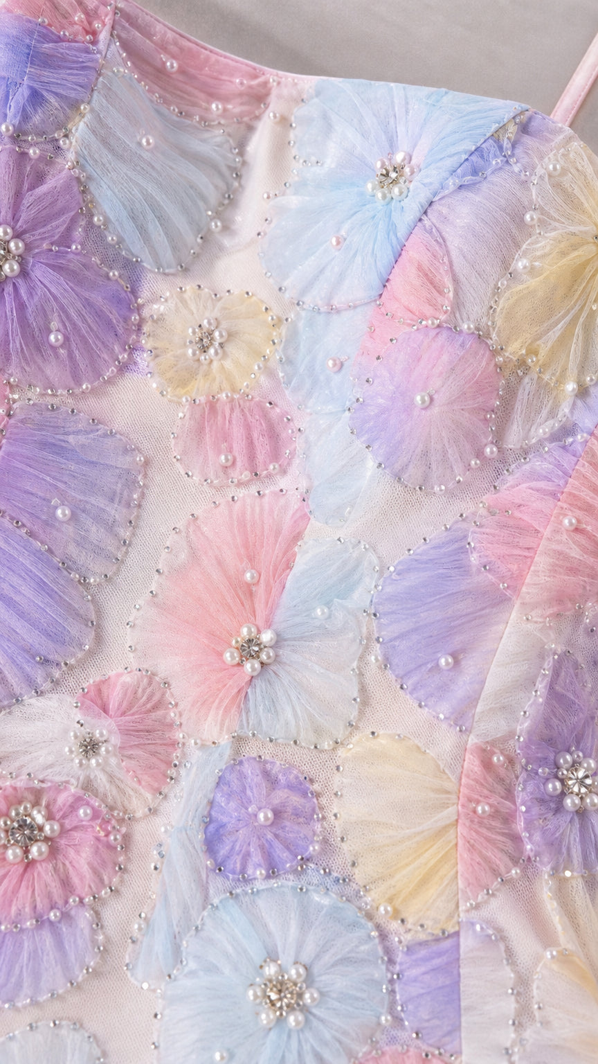 Close-up detail of 3D pleated floral appliques with pearl and rhinestone centers