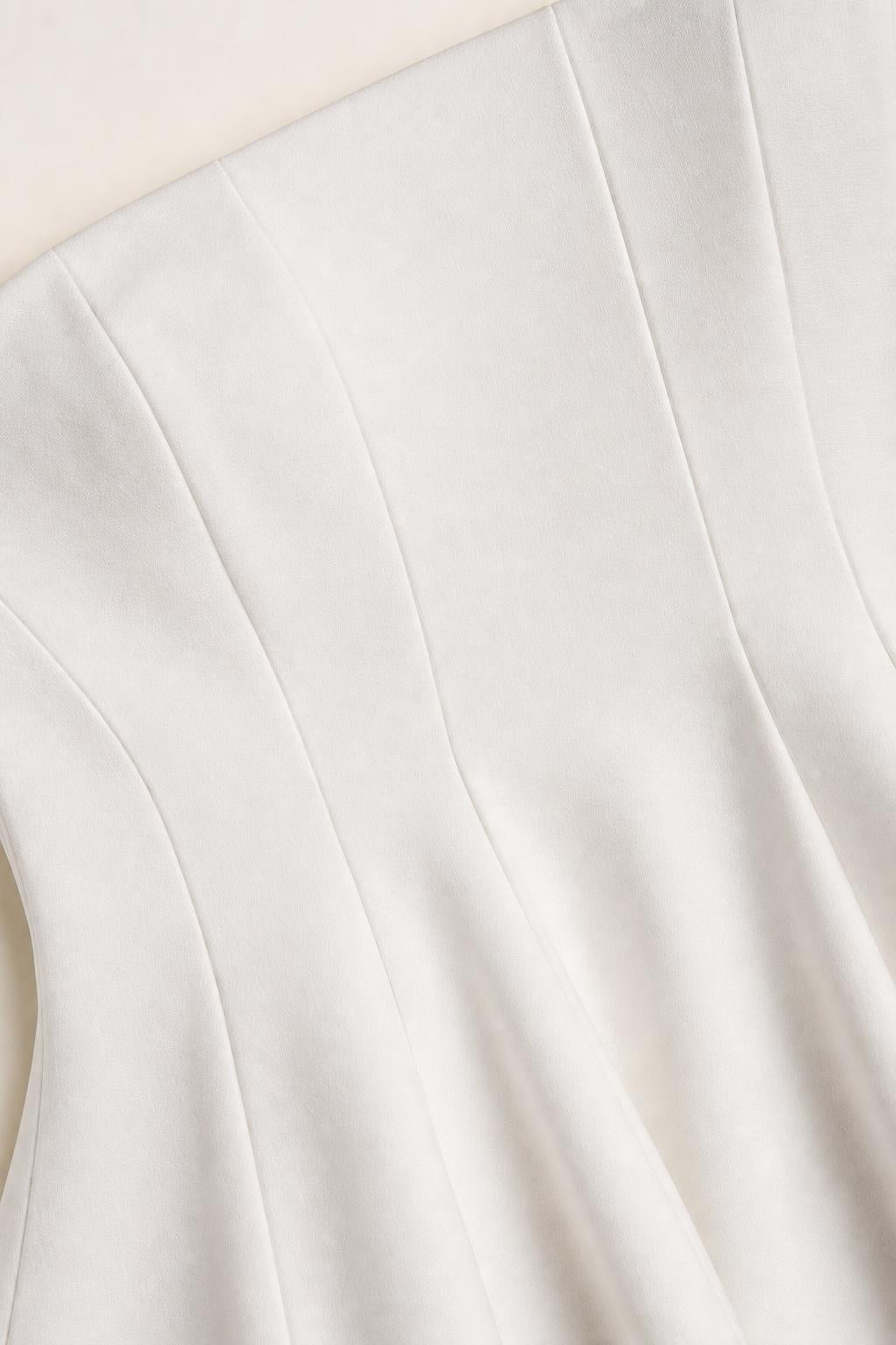 Close-up of white peplum top fabric and seaming details