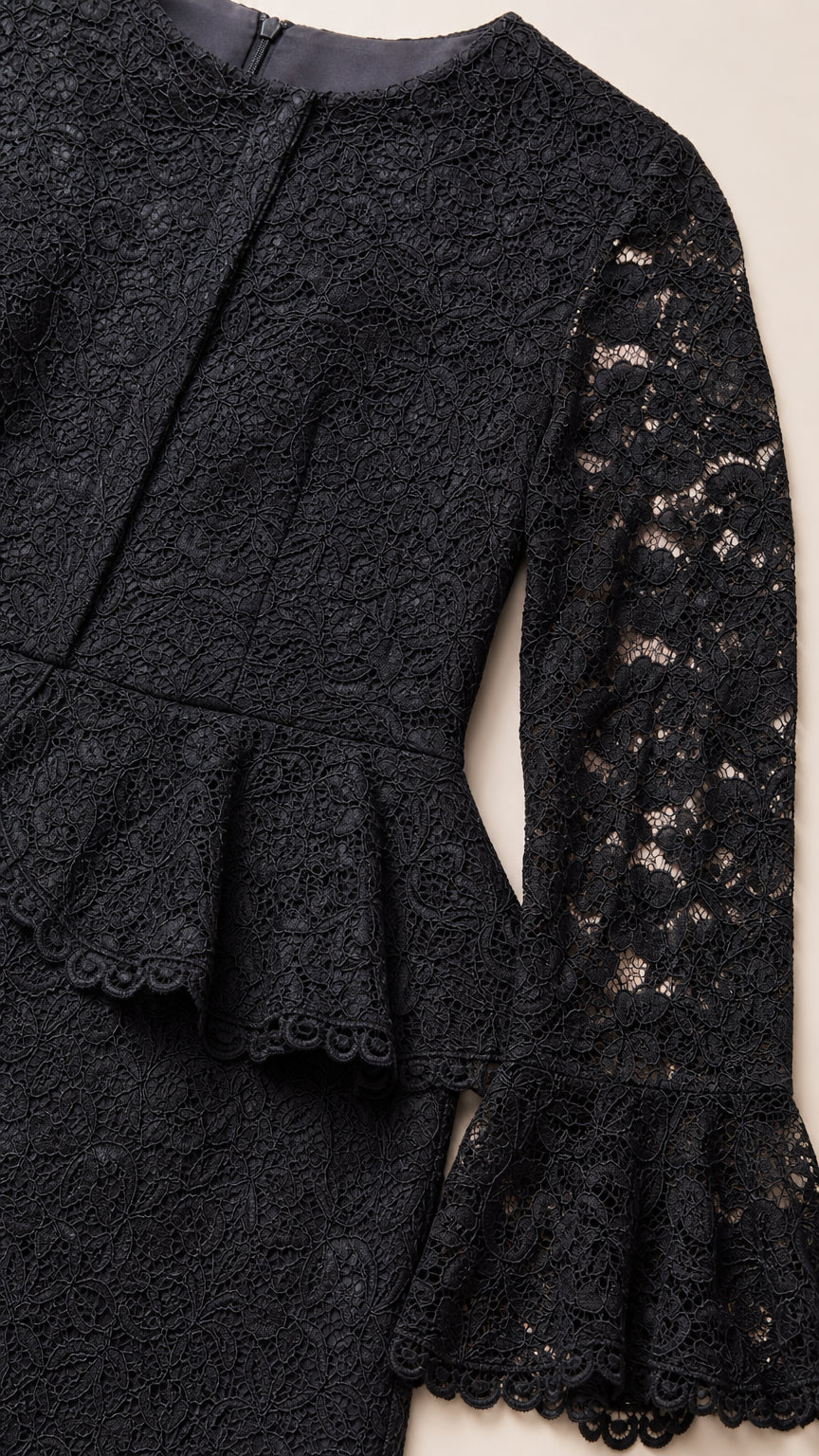 Close-up detail of black floral lace fabric, peplum waist, and bell cuff