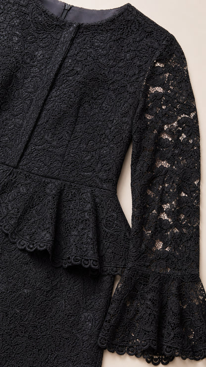 Close-up detail of black floral lace fabric, peplum waist, and bell cuff