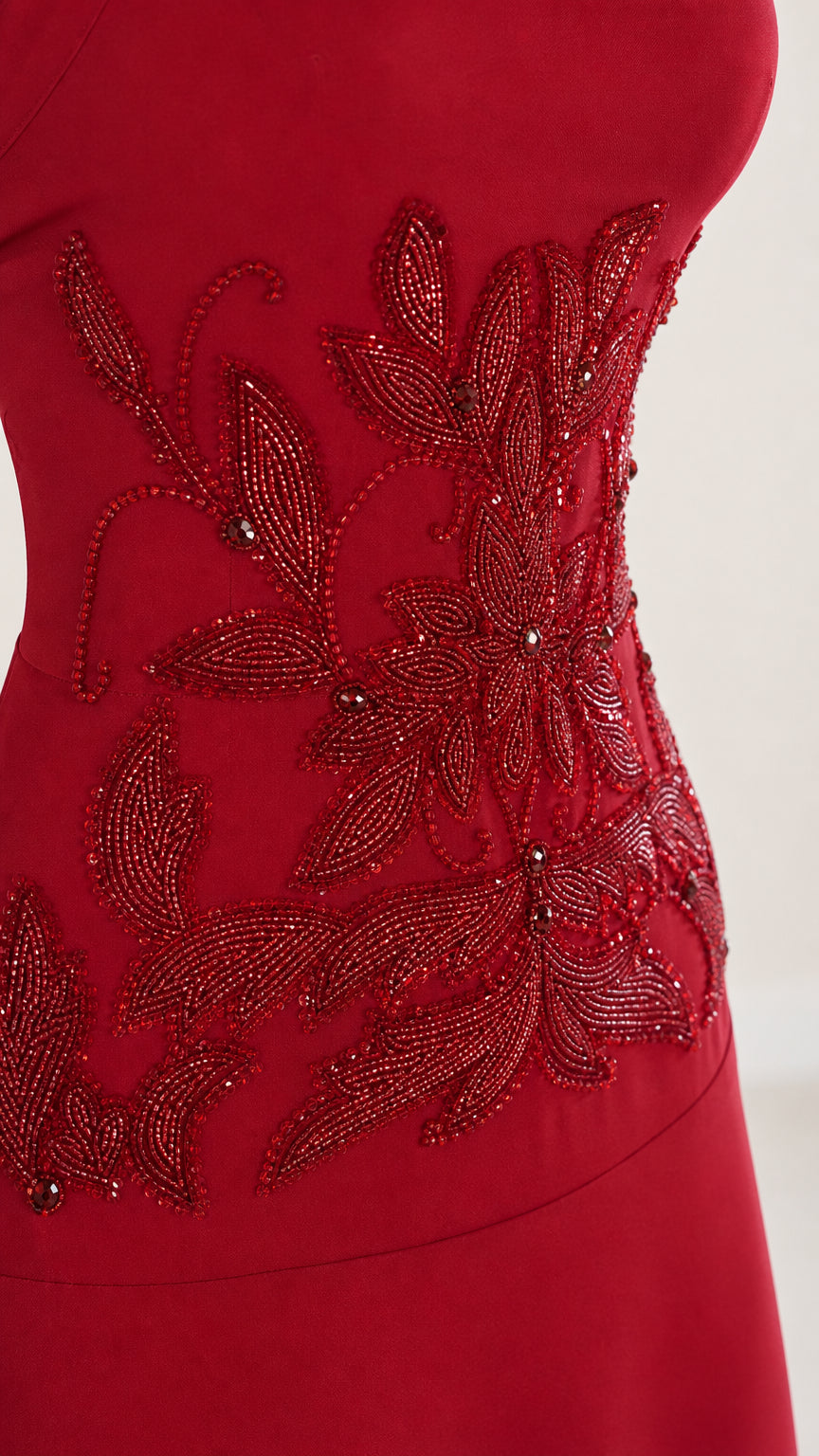 Close-up detail of red beaded embroidery on bodice
