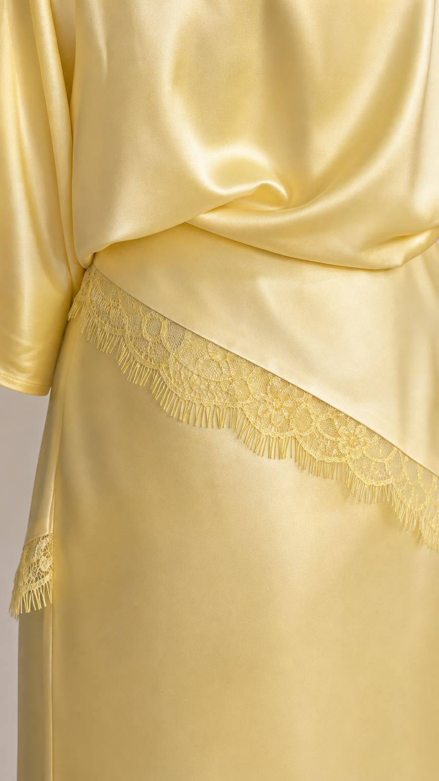 Close up of yellow satin top and lace trim skirt detail