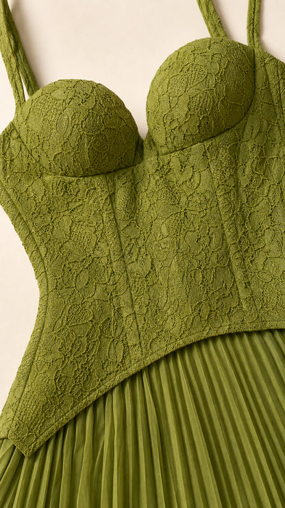 Close-up detail of structured lace bodice and pleated skirt transition in olive