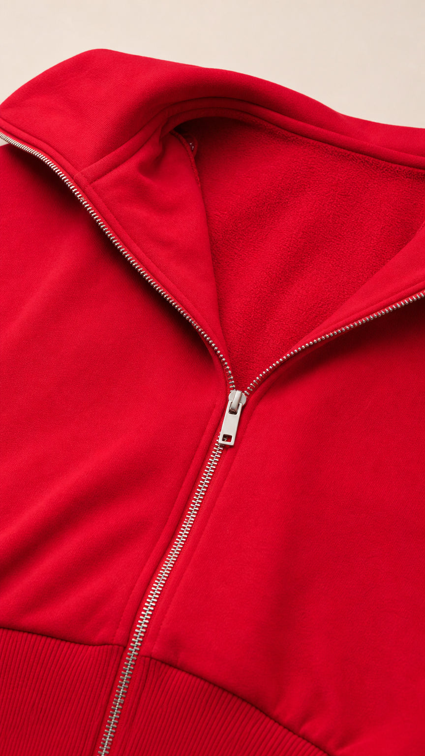 Close-up detail of red zip-up hoodie showing fleece lining and metal zipper