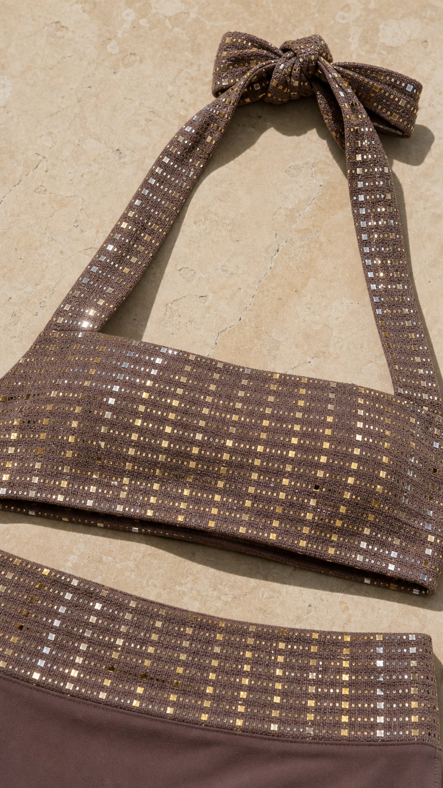 Close-up detail of sequin-accented brown halter top and skirt waistband