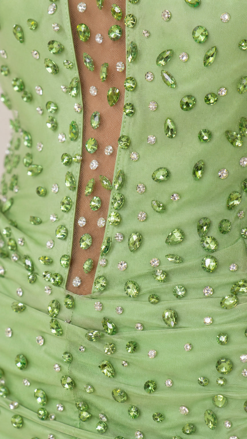 Close-up detail of green rhinestone beading and sheer illusion mesh plunge