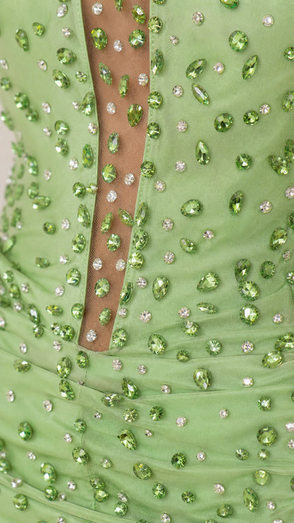 Close-up detail of green rhinestone beading and sheer illusion mesh plunge
