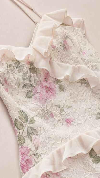 Close-up of fabric detail showing white floral lace and ruffle trim