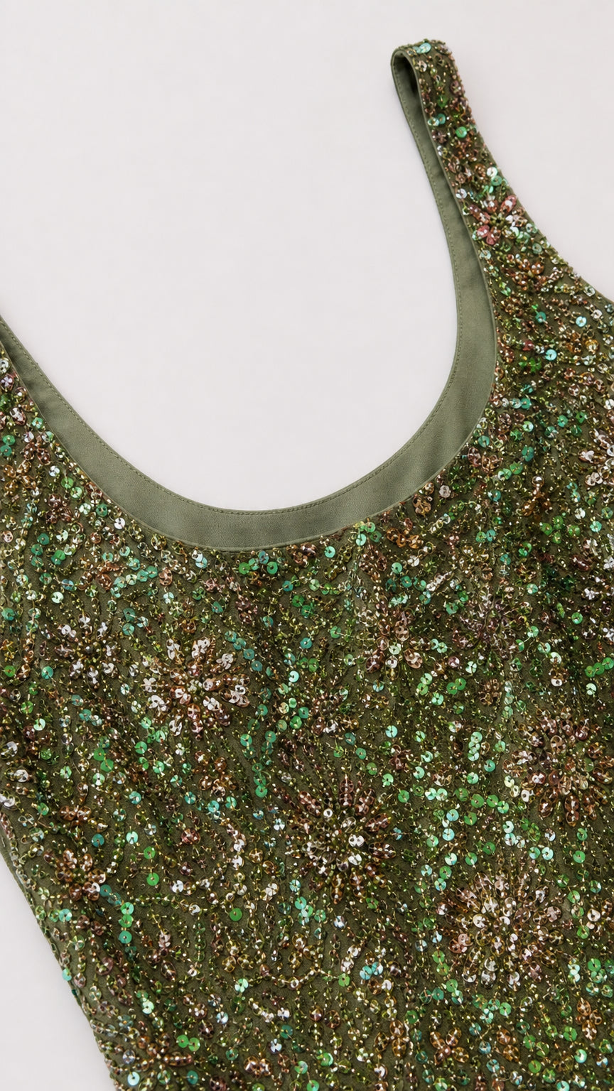 Close-up detail of scoop neckline and green sequin fabric texture
