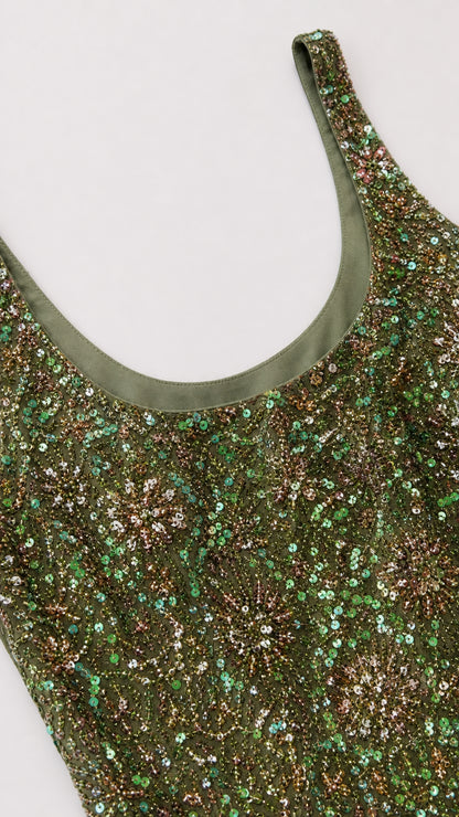 Close-up detail of scoop neckline and green sequin fabric texture