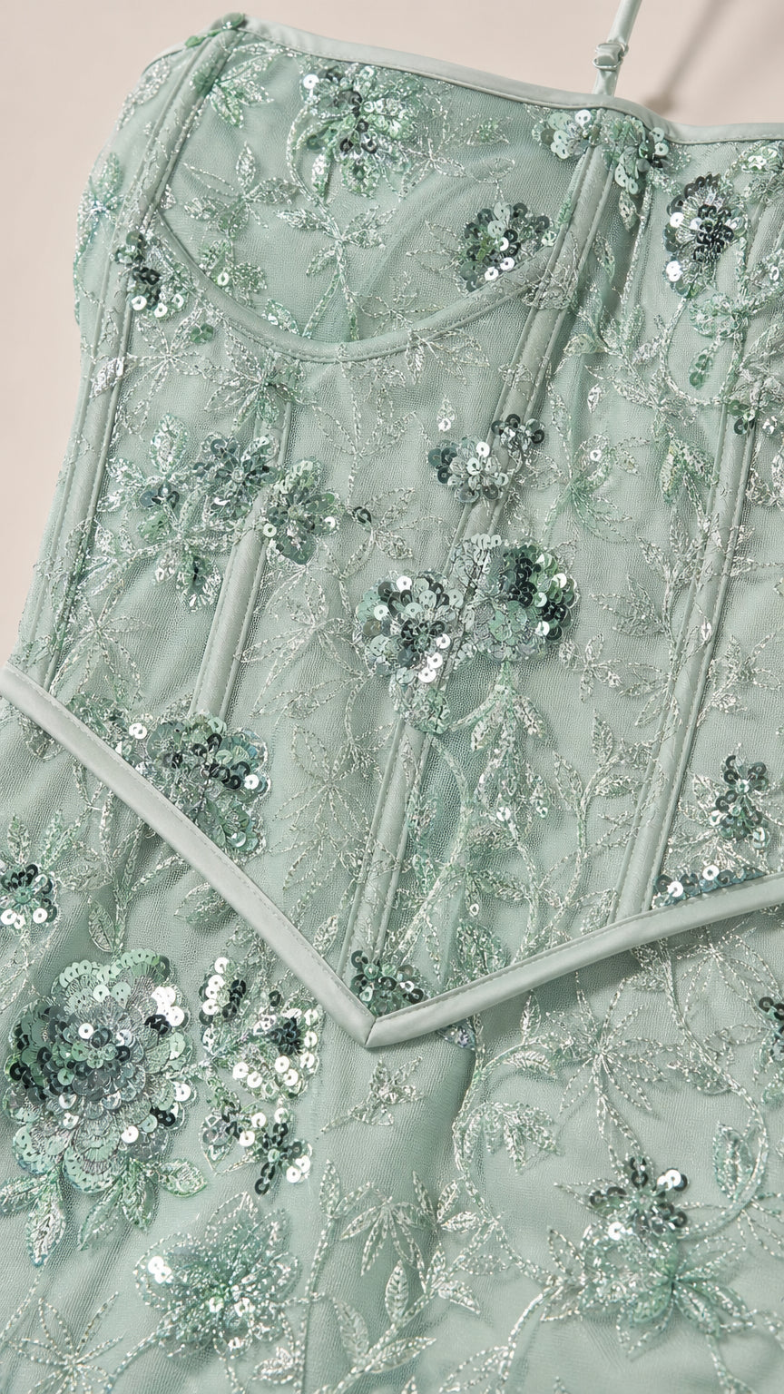 Close-up detail of sage green sequin floral embroidery and corset bodice