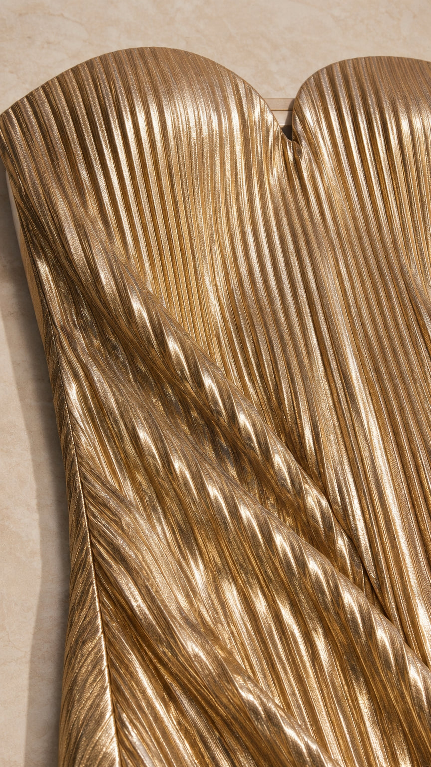 Close-up detail of shimmering gold accordion pleated fabric texture