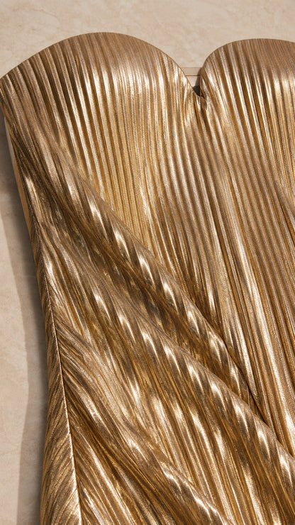 Close-up detail of shimmering gold accordion pleated fabric texture