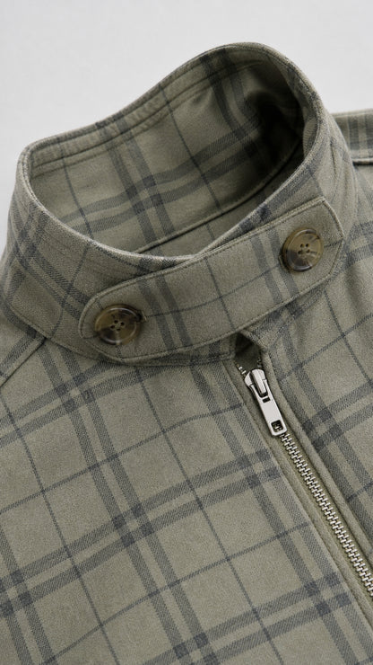 Close-up of stand collar with button tab and zipper on sage green plaid jacket