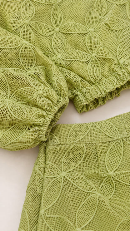 Close-up of sleeve cuff and textured fabric detail in sage green