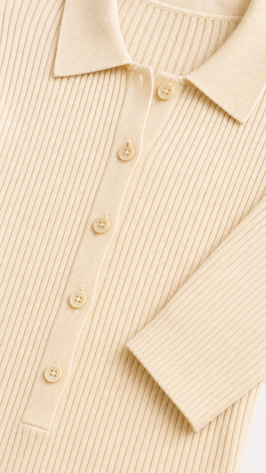 Close-up detail of cream ribbed knit fabric, collar, and button placket