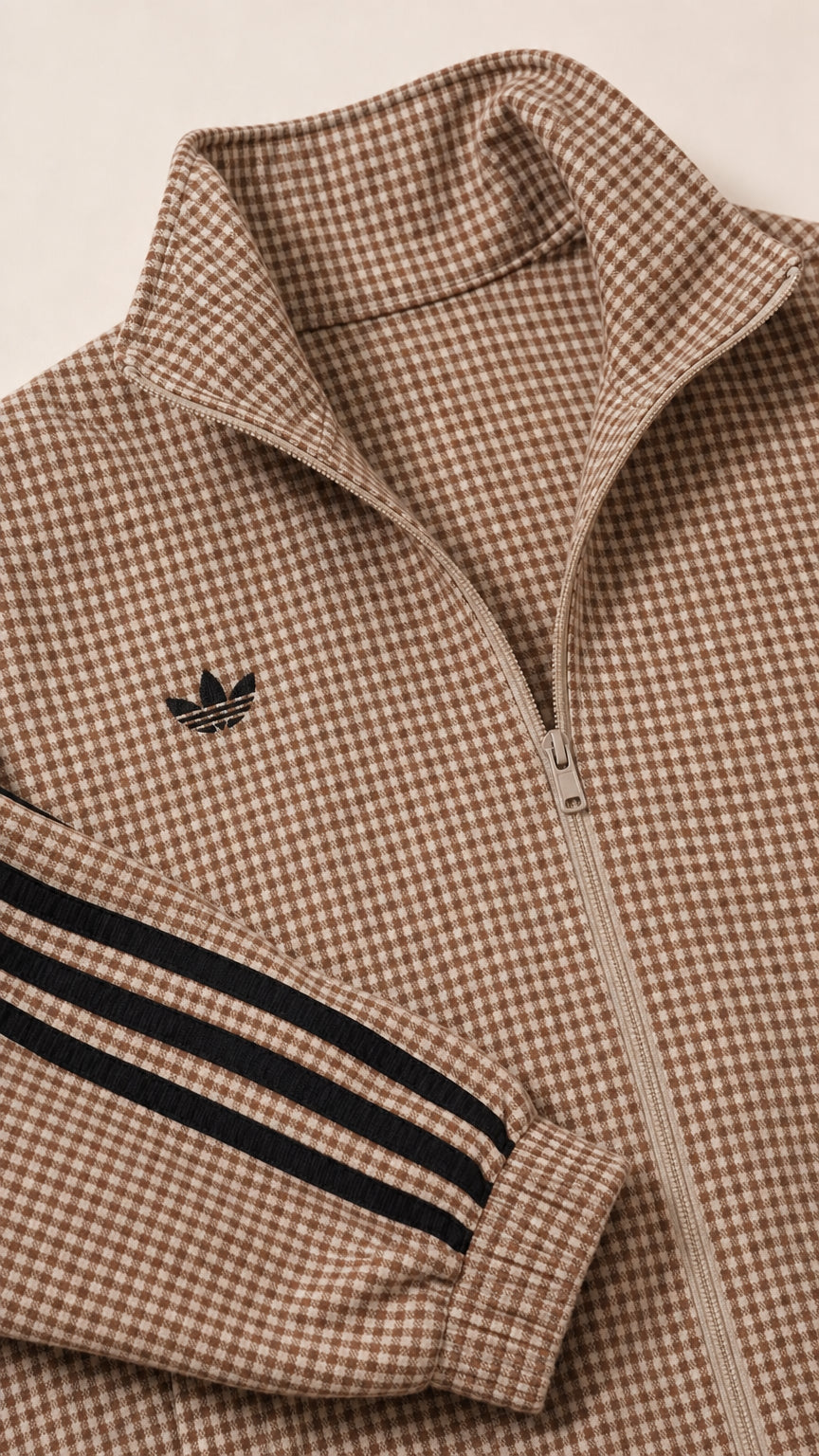 Close-up detail of houndstooth pattern, zipper, and side stripes on camel track jacket