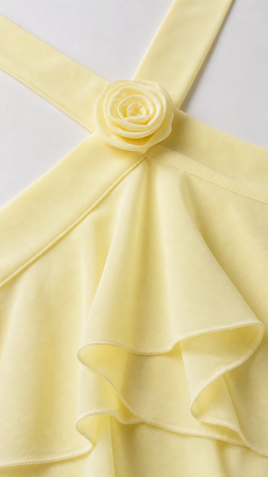 Close-up detail of 3D fabric flower applique on yellow halter neckline