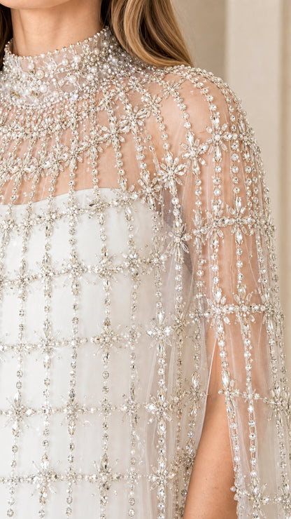 Close-up detail of high neck faux pearl and crystal beading on cape overlay