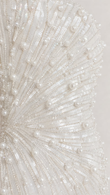 Close-up detail of white sequin and pearl sunburst embroidery pattern