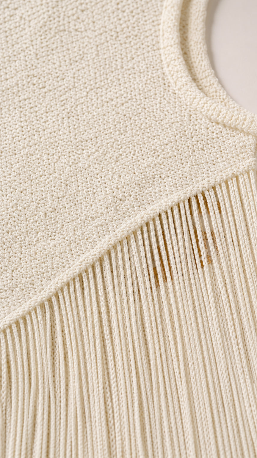 Close-up detail of the knit texture and fringe hem