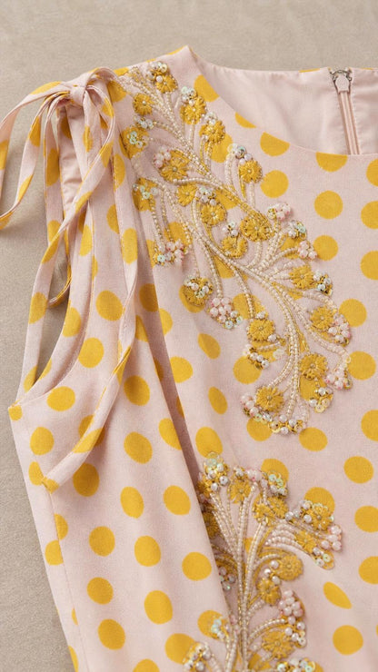 Close-up of shoulder tie and bodice embroidery on polka dot dress