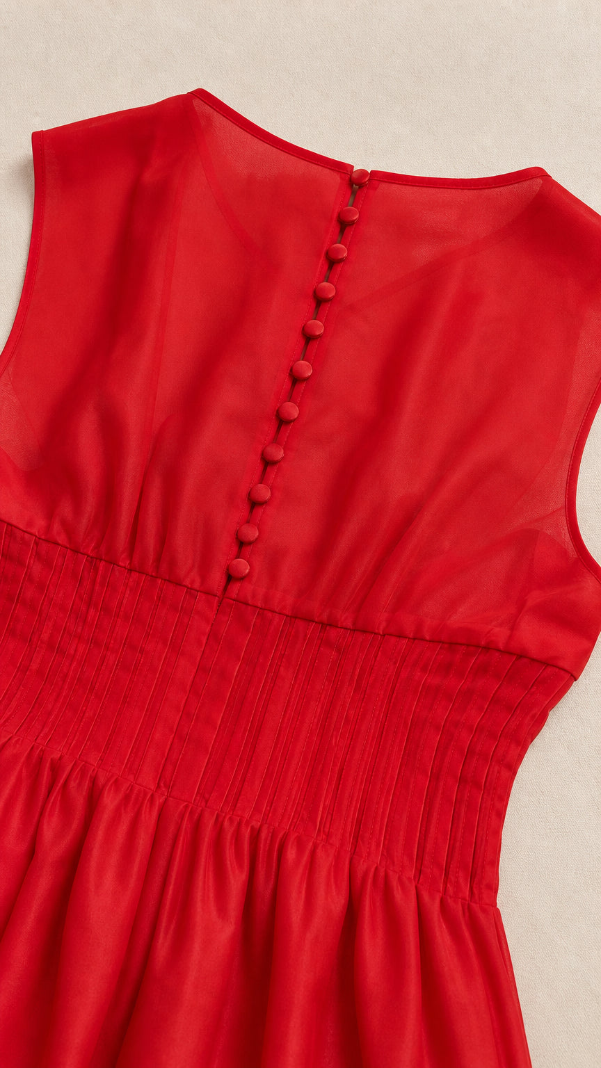 Close-up of back button closure and pleated waist on red dress