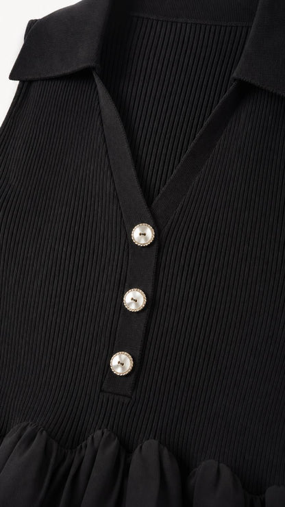 Close-up of ribbed collar and crystal button details on black dress