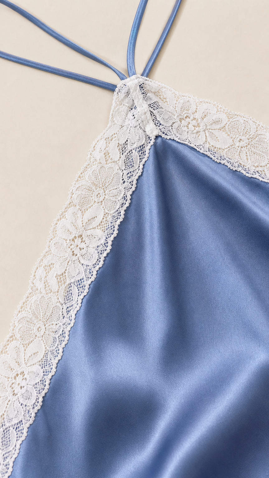 Close-up of lace trim detail on blue satin dress